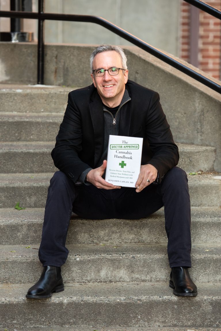 Dr. Benjamin Caplan holding The Doctor-Approved Cannabis Handbook